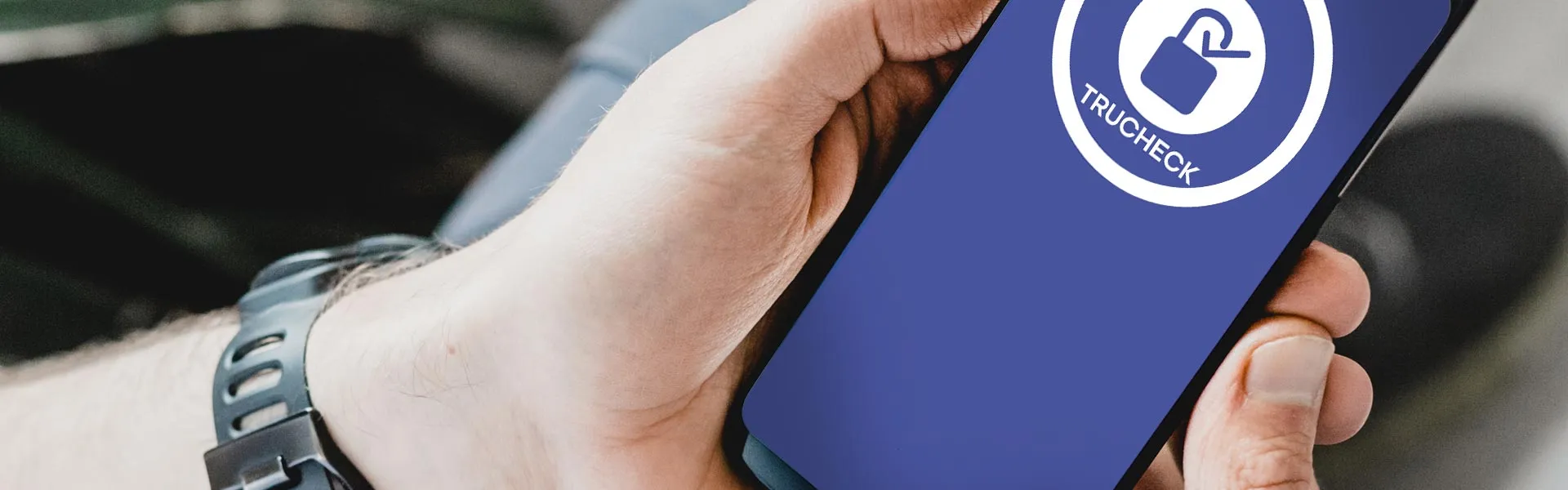 Hand holding a smartphone displaying the Trucheck padlock logo